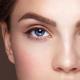 Model with deep blue eyes and thick brows looking at the camera