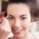 Smiling model with rolls in her hair getting the pomade applied