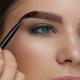 Model with thick brows applying the mediumpomade